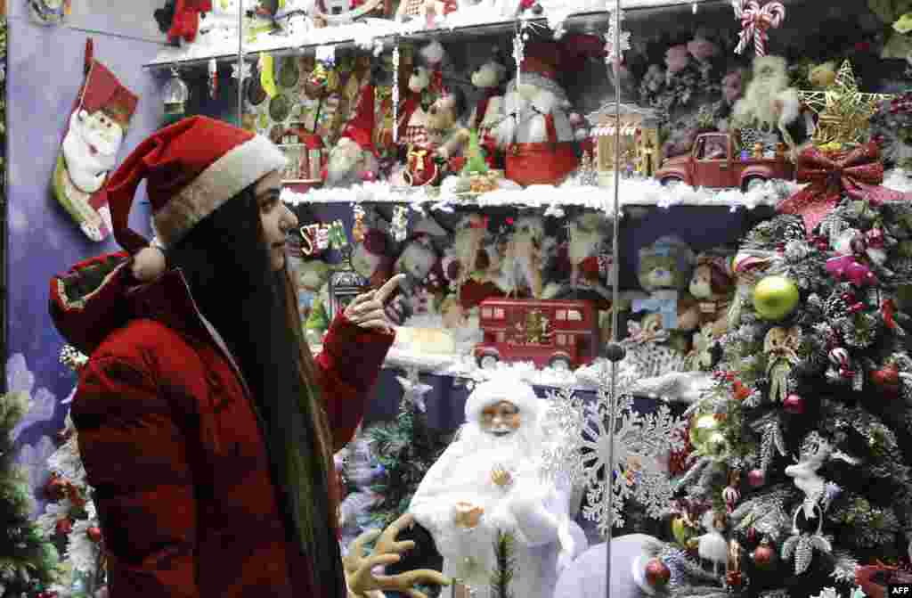 A woman looking at Christmas decorations in Tehran on December 25.&nbsp; As of December 26, protests were ongoing in some parts of Iran over the deadly crackdowns on demonstrations sparked by Amini&#39;s death in September.&nbsp; &nbsp;