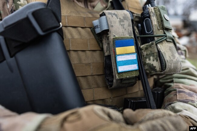 Военен носи униформа със знамето на "Свобода за Русия" под украинското знаме