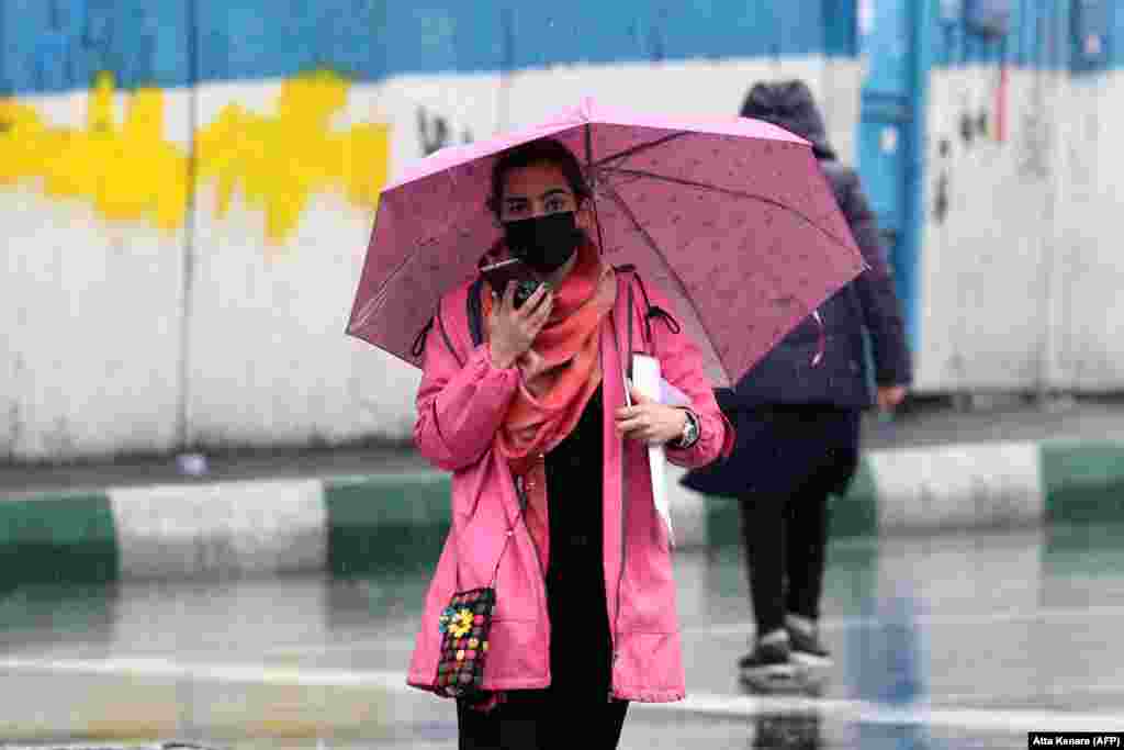 A woman walks through Tehran on December 4.&nbsp; Amid massive unrest following Amini&#39;s death, Iran apparently cut back patrols of the morality police in early December. A small but growing number of women have since taken to the streets in defiance of the Islamic government&#39;s law on head scarves by wearing only hats -- or no head covering at all.