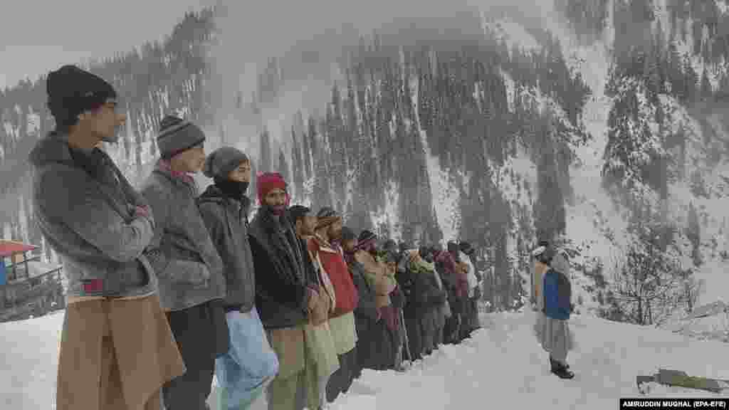 Njerëzit duke marrë pjesë në një funeral në një fshat të mbuluar me borë në Luginën Neelum në Kashmirin e administruar nga Pakistani.