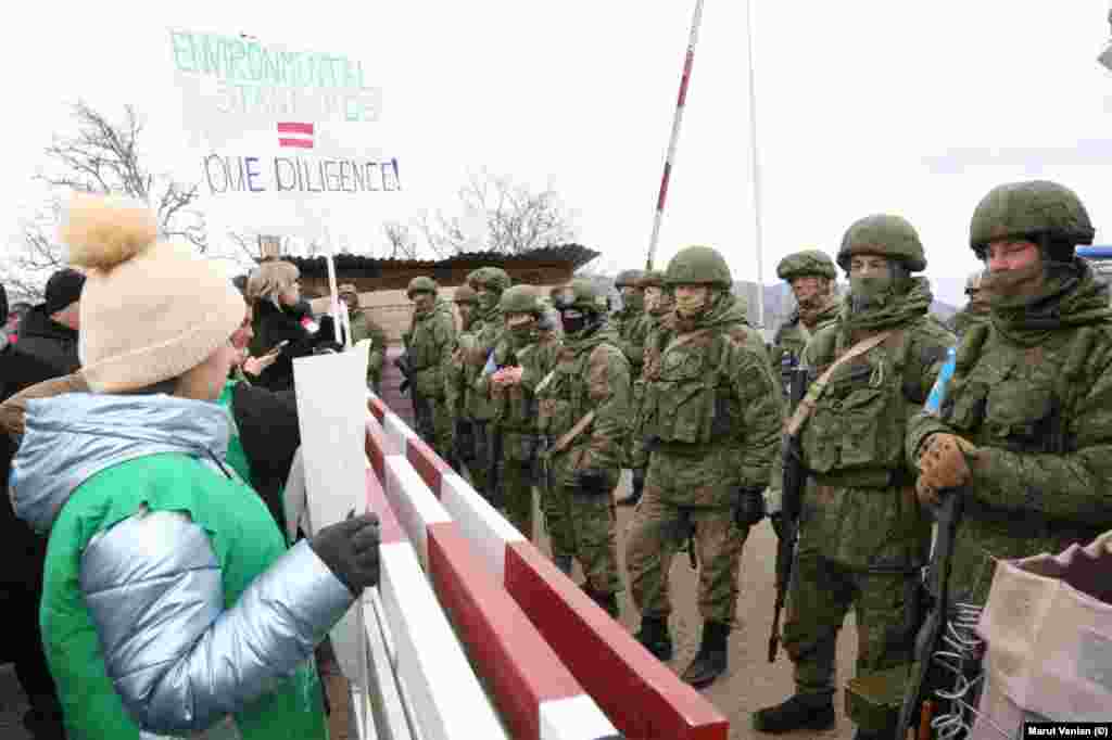 Российские миротворцы стоят перед азербайджанцами, перекрывшими трассу, соединяющую Нагорный Карабах с Арменией, 13 декабря (фото Azertac). Азербайджанцы перекрыли Лачинский коридор 12 декабря. Они называют себя &laquo;экоактивистами&raquo; и протестуют против того, что армяне &quot;незаконно&quot; добывают золото в Нагорном Карабахе. Полиция в Азербайджане обычно разгоняет спонтанные протесты в течение нескольких минут, и многие обвиняют Баку в организации лачинского протеста с целью оказания давления на армян в Армении и Карабахе.