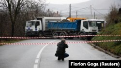 Një gazetar duke fotografuar barrikadën e vendosur në fshatin Rudarë. 