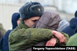 Un bărbat îmbrățișează o femeie, în timpul ceremoniei de petrecere a rezerviștilor mobilizați, la Gara din Chita, în Orientul Îndepărtat al Rusiei, 7 noiembrie 2022