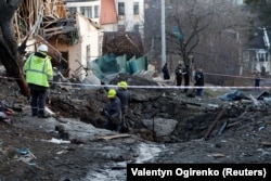 La gente trabaja en el lugar de un ataque con misiles rusos en Kyiv el 31 de diciembre.