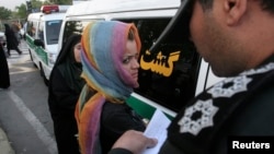 Poliția moralității notează numele unei femei reținute într-un raid contra „corupției sociale” la Teheran, 18 iunie 2008. 