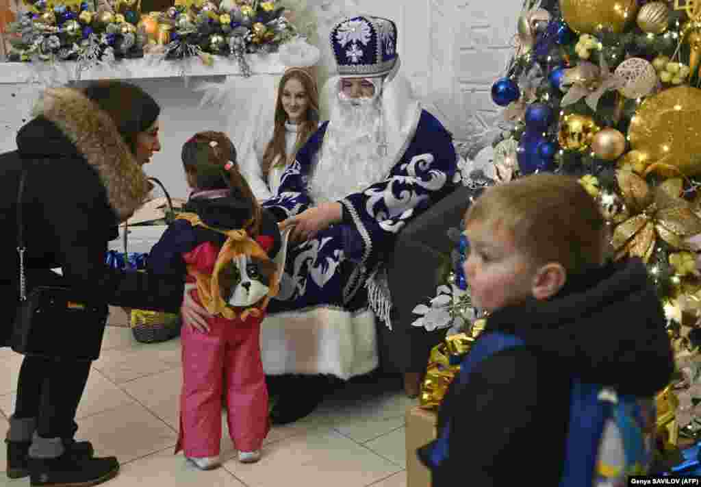 A man dressed as St. Nicholas and a woman dressed as an angel greet children at the festively decorated library on December 23. &quot;We received some sweets, and that&#39;s why we come with our children on this occasion, in order to lift our spirits,&quot; said Irpin resident Viktoria Voskresova.