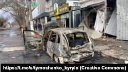 Izgoreli automobil na ulici u Hersonu nakon ruskih udara na ukrajinski lučki grad 24. decembra.