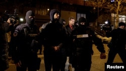 Andrew Tate (center) and Tristan Tate (center right) are escorted by police officers in Bucharest after being detained on December 29.