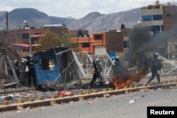 Полицейские пытаются предотвратить штурм манифестантами аэропорта в городе Хулиака на крайнем юге Перу. 9 января 2022 года