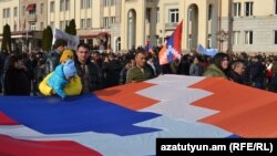 Nagorno Karabakh - People carry a giant Karabakh flag during a demonstration in Stepanakert, December 25, 2022.