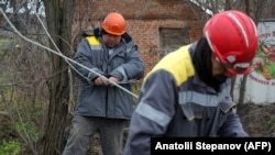 Workers repair broken power lines in a village in Ukraine's Donetsk region amid the Russian invasion of the country. 