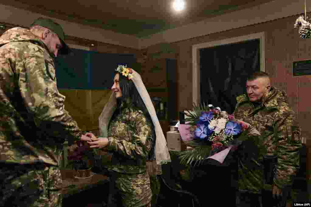 Військові медики Євгенія та Олександр обмінюються обручками під час весільної церемонії в Лимані.