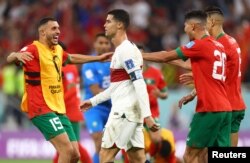 Portughezul Cristiano Ronaldo este surprins în timpul bucuriei jucătorilor marocani, după calificarea în semifinalele CM 2022, 10 decembrie 2022.