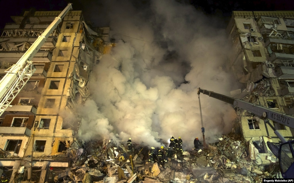 I soccorritori rimuovono i detriti da un edificio residenziale a seguito di un attacco missilistico russo a Dnipro il 14 gennaio.