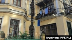 Украинский флаг привязан к пальме у старого дома в Батуми