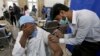 A man receives the Sinopharm coronavirus vaccine from a healthcare worker at a vaccination center in Karachi on March 10.