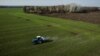 An aerial view shows a tractor spreading fertilizer on a wheat field near the village of Yakovlivka, outside Kharkiv, after it was hit by a Russian aerial bombardment on April 5.