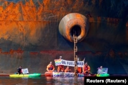 Az Ust-Luga orosz olajtankernél tiltakozik a Greenpeace a norvégiai Åsgårdstrand kikötőjében 2022. április 25-én