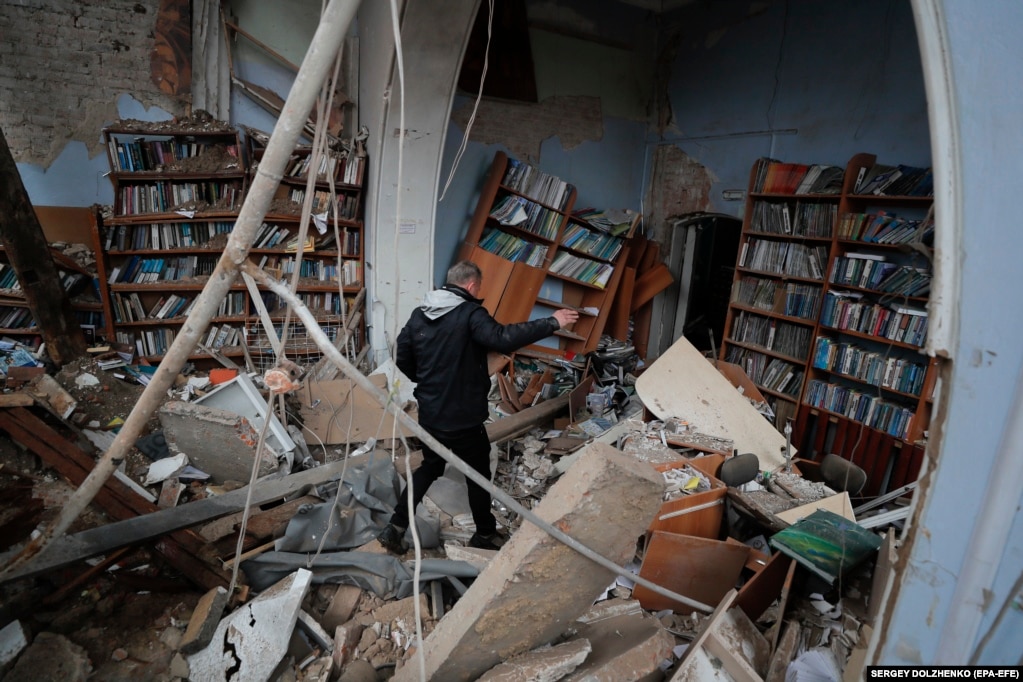 Një bibliotekë është bombarduar në qytetin e Çernihivit. Qyteti është rimarrë nga trupat ukrainase. Një burrë duke shikuar dëmet, më 9 prill.