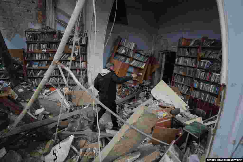 Një bibliotekë është bombarduar në qytetin e Çernihivit. Qyteti është rimarrë nga trupat ukrainase. Një burrë duke shikuar dëmet, më 9 prill.