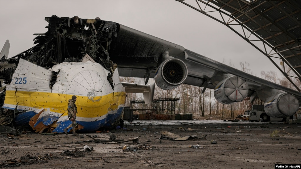 Një ushtar ukrainas duke ecur pranë mbetjeve të avionit transportues Antonov An-225 Mriya, më 2 prill 2022. Mriya, i cili kishte qenë avioni më i madh në botë, u shkatërrua nga një sulm rus më 27 shkurt gjatë luftimeve në aeroportin Antonov në Hostomel. Mriya, që do të thotë "ëndërr" ose "frymëzim", ishte e dashur nga entuziastët e aviacionit në mbarë botën.