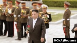 Severnokorejski lider Kim Džon Un sa ružom u ruci kako bi je stavio na groblje revolucionarnih mučenika na planini Daesong na obeležavanju 90. godišnjice osnivanja Korejske narodne revolucionarne armije u Pjongjangu, Severna Koreja, 26. april 2022.