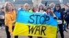 Iryna Horoshayeva (left) helps hold up an anti-war banner at a demonstration in Iasi, Romania. 