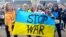 Iryna Horoshayeva (left) helps hold up an anti-war banner at a demonstration in Iasi, Romania. 