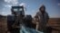 A Ukrainian farmer is seen in a field with a tractor. Ukraine is one of the world's largest suppliers of grain.