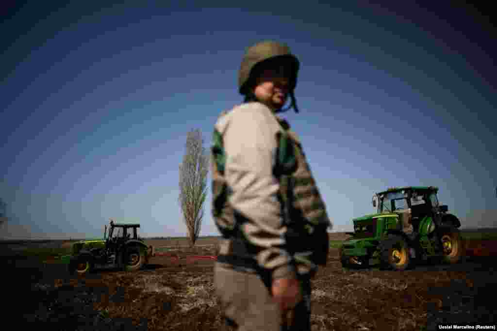 A Ukrainian farmer, wearing body armor and a helmet, works the topsoil in a field amid Russia&#39;s invasion of Ukraine in the Zaporizhzhya region on April 26.