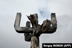 Fotografija nastala 27. marta 2022. prikazuje pogled na spomenik Menora, postavljen na mjesto masovnog ubijanja Jevreja tokom Drugog svjetskog rata, dan nakon što je oštećen u ruskom granatiranju, na ulazu u Memorijalni kompleks holokausta na istočnoj periferiji Harkiva.