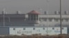 In a December 2018 photo, a guard tower and barbed-wire fences are seen around a facility in western China's Xinjiang region, one of a growing number of internment camps there.