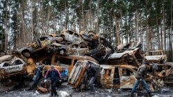 Locuitori din Irpin, în fața mașinilor distruse