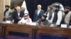 Zalmay Khalilzad (back row, center) attends the signing of an oil and gas deal with senior Taliban officials in Kabul on September 7.
