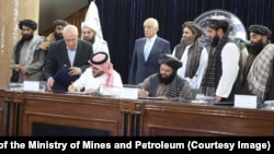 Zalmay Khalilzad (back row, center) attends the signing of an oil and gas deal with senior Taliban officials in Kabul on September 7.