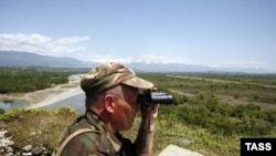 A Russian border guard patrols Abkhazia's border with Georgia proper near the bridge across the Inguri River.