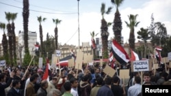 Demonstranti drže plakate za vreme demonstracija u gradu Douma, 27. april 2011.