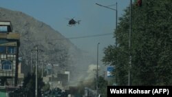 AFGHANISTAN -- Smoke and dust (C) rise following an air strike from an Afghan military helicopter during ongoing clashes between Afghan security forces and militants near the Eid Gah Mosque in Kabul, August 21, 2018