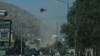 Smoke and dust (C) rise following an air strike from an Afghan military helicopter during ongoing clashes between Afghan security forces and militants near the Eid Gah Mosque in Kabul on August 21.