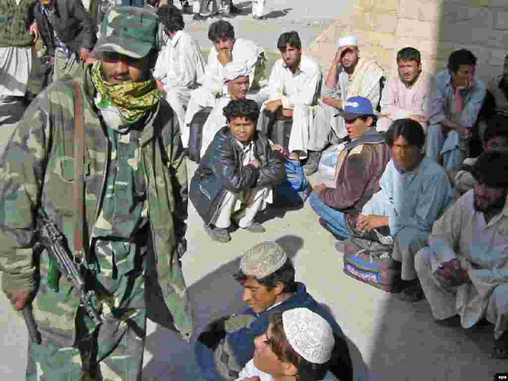 Afghanistan -- Afghan Army soldier stands guard after the Afghan men were handed over to Afghan authorities on Pakistan-Afghanistan border Chaman, 09Mar2007 - Caption: epa00952223 Afghan Army soldiers stands guard after the Afghan men were handed over to Afghan authorities on Pakistan-Afghanistan border Chaman on Friday 09 March 2007. Pakistan on Friday handed over 108 Afghan nationals to Afghanistan. Pakistani law-enforcement agencies had arrested the persons from Turbat Chaman and other areas of Balochistan for having entered into Pakistan without legal documents