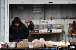 O vânzătoare la piața satului Kuibîșev, în apropiere de aeroportul din Donețk, controlat de forțele Kievului.