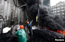 Киевтің орталығында билікке наразылар автокөлік дөңгелектерін өртеп, милиция жасағының жолына бөгет қойып жатыр. 25 қаңтар 2014 жыл.