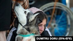 Tânără refugiată din Ucraina îmbrățișându-și câinele la Palanca, Republica Moldova, 17 martie 2022.