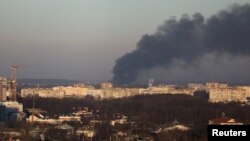 Dim se diže iz zgrade fabrike u blizini aerodroma Lavov, dok se invazija na Ukrajinu nastavlja, u Lavovu, Ukrajina, 18. marta 2022. 