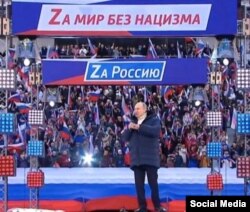 Az a bizonyos latin Z – a háborúpártiság jelének számító betű váltotta fel Putyin nagygyűlésén a cirill Z-t. A rendezvény eredeti célja a Krím elcsatolásának nyolcadik évfordulójáról történő megemlékezés volt