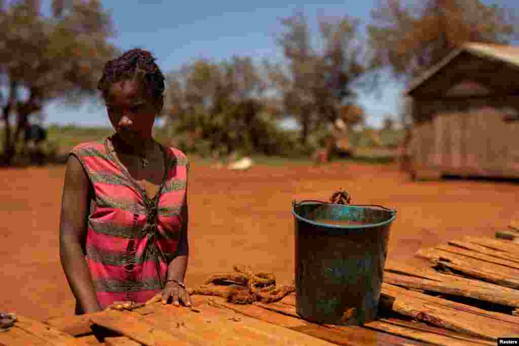 Egy fiatal nő lezárja egy kút tetejét, miután vizet gyűjtött egy vödörbe az Androy régióban