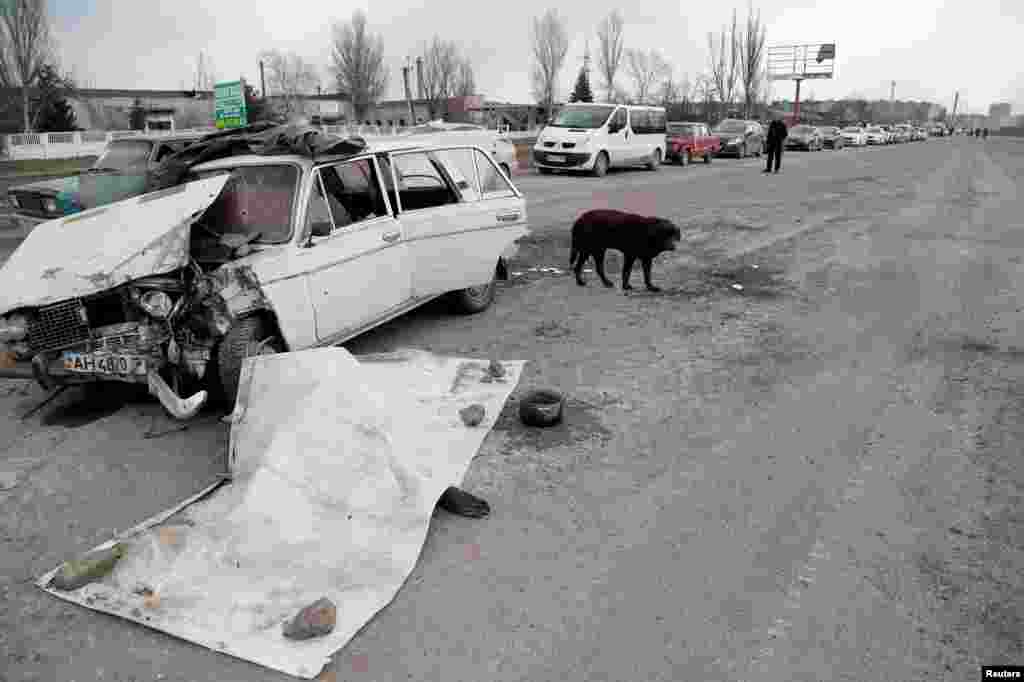 Cars drive by the bodies of people killed in Mariupol, on March 17.