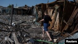 A man walks on the site of a municipal market destroyed by a Russian military strike in the border town of Vovchansk on Junje 4.