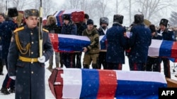 Cossacks carry coffins containing the remains of Russian and French soldiers during a burial ceremony in the town of Vyazma, west of Moscow, on February 13. 