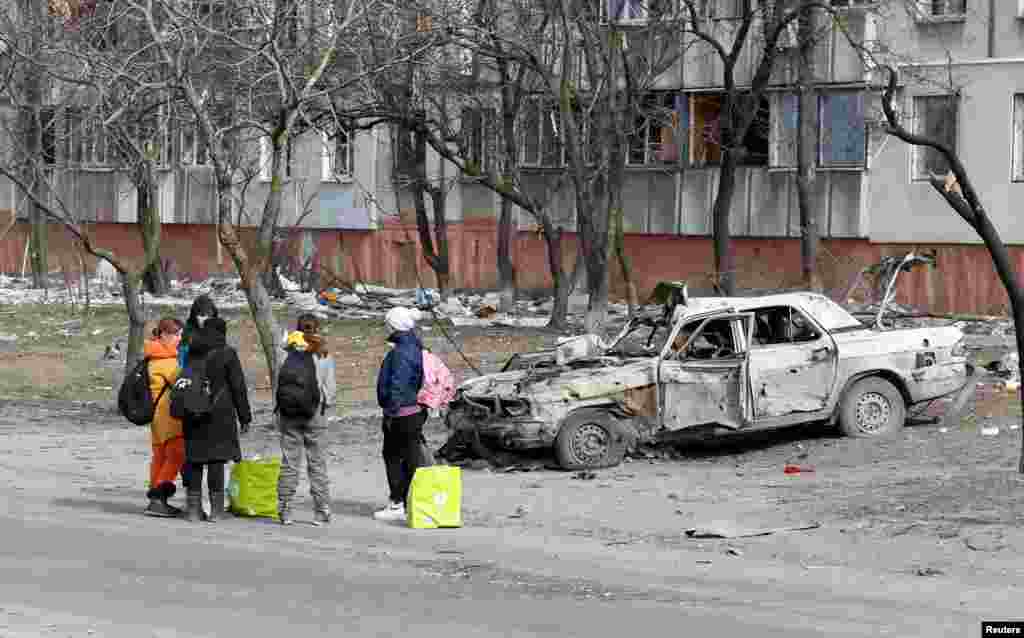 Бегалци се собираат на улица со надеж дека ќе го напуштат разурнатиот од војна Мариупол, 20 март 2022 година.